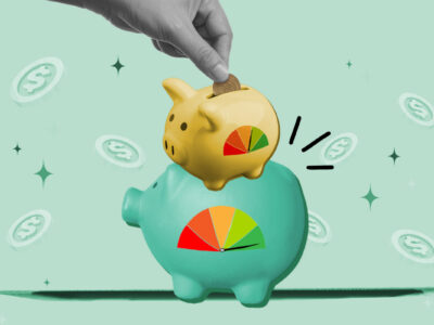 Piggy bank with credit score gauge on top of another piggy bank